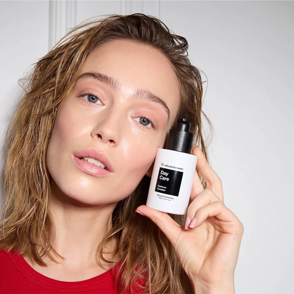 Woman holding Day Care Serum and Hyaluronic Cream for skin.